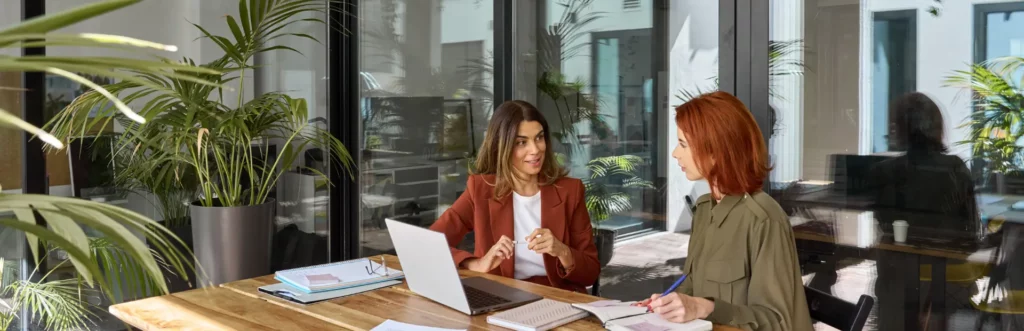 Two women talking at an office table